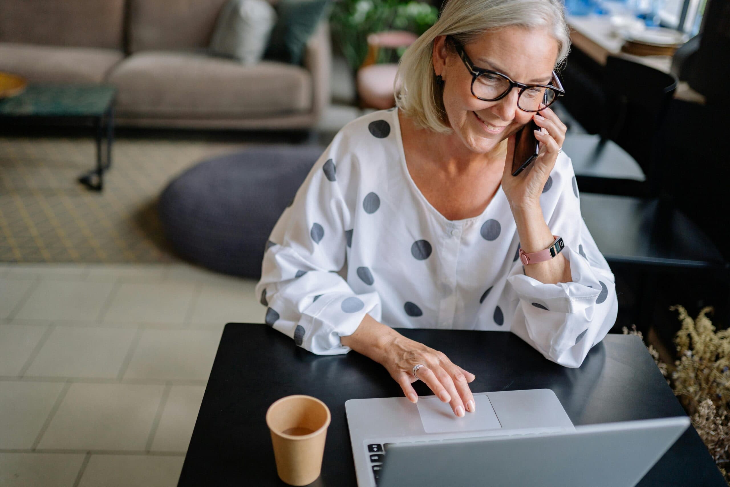woman in phone in front of laptop